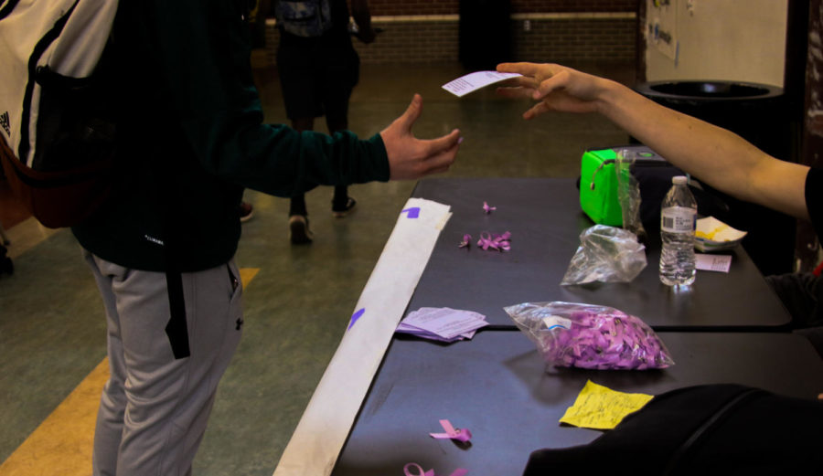 Working during lunch, StuCo members hand out informational flyers and purple ribbons to students. StuCo’s goal for the table was to spread awareness about eating disorders, which are very common among teens. “It was important to me to hand out ribbons because I wanted to make sure that it’s known because it is a severe thing,” freshman Sophie Johnston said. “I really do think that the table impacted people.”