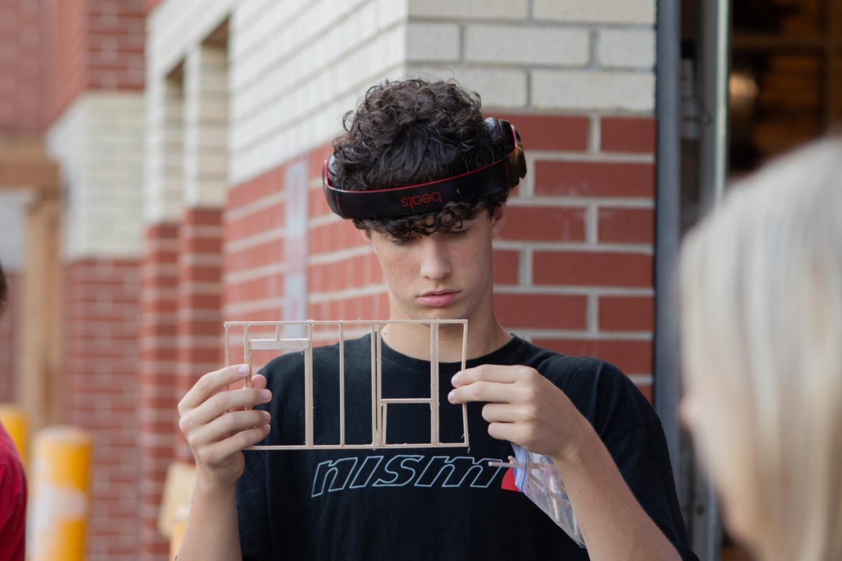 Working on a project, sophomore Skyler Hansen examines one of the walls. Hansen explained that Geometry and Construction is usually divided up between two periods. “You do an hour of either geometry or construction, depending on what the teachers want to do at the beginning. Then the next hour, you do whatever you didn’t do in the first hour,” Hansen said. “In geometry, you’ll learn a specific set of [information], and in construction, you use that after you learn the geometry.”
