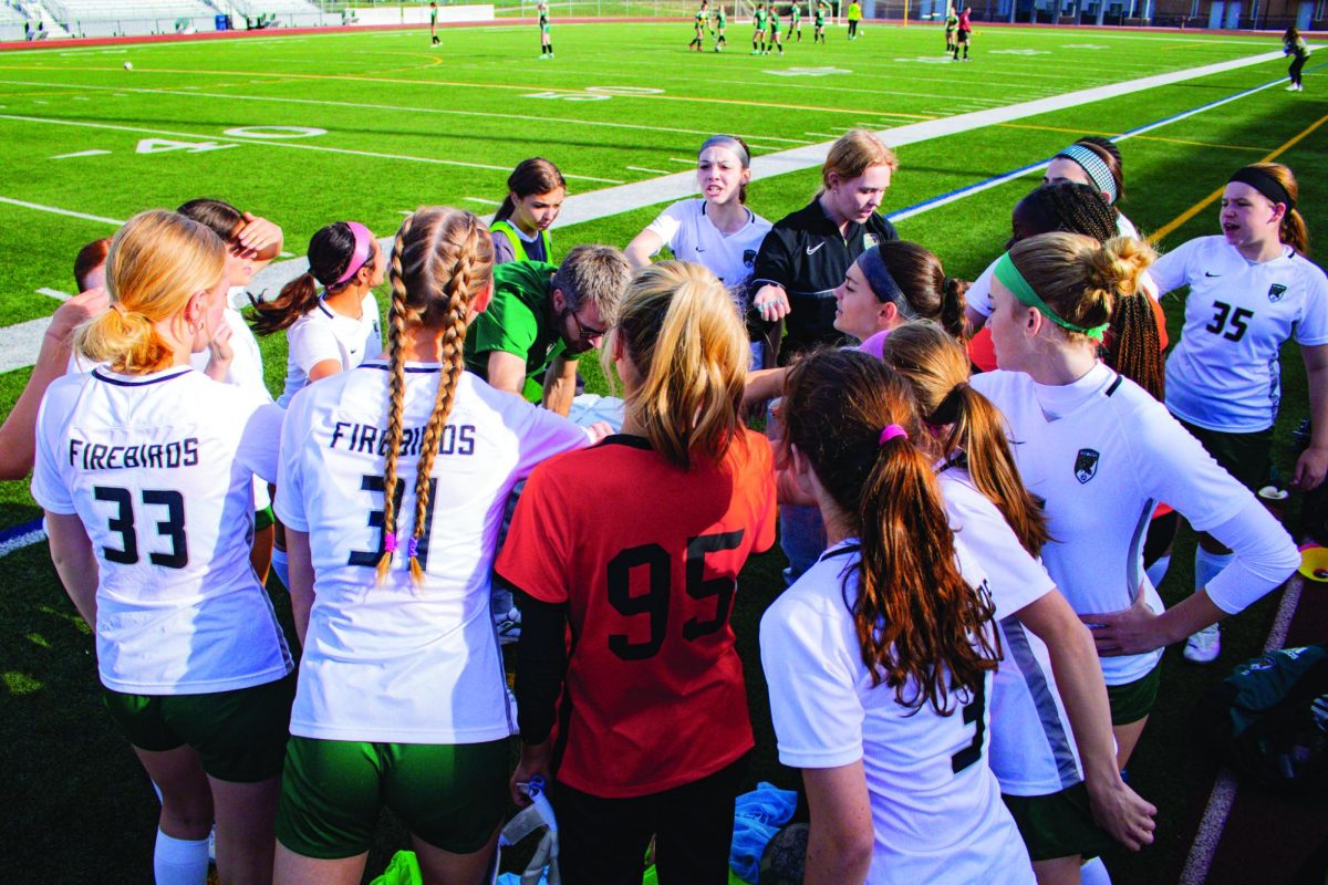 Gathering between plays, the girls JV soccer team meets for a time out.