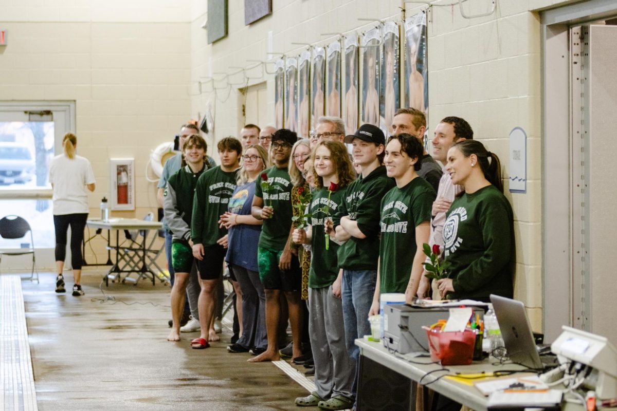 The seniors of the Boys Swim and Dive team and their families pose for a photo after receiving their roses.