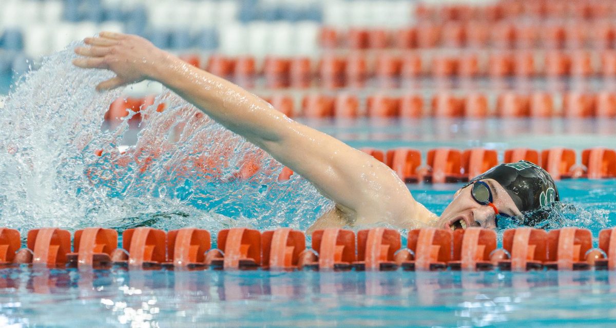 Coming up for air, sophomore Sebastian Iversen swims the freestyle at the Senior Night meet on Jan. 16.