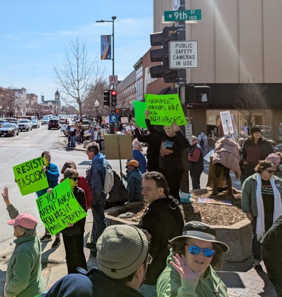 Holding signs and chanting, Lawrence residents protest downtown.