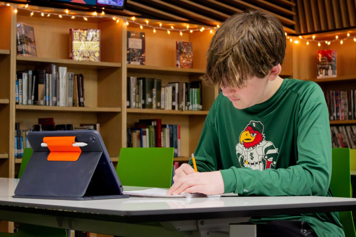 In the library, freshman Crosby Kober studies for the AP Human Geography test.