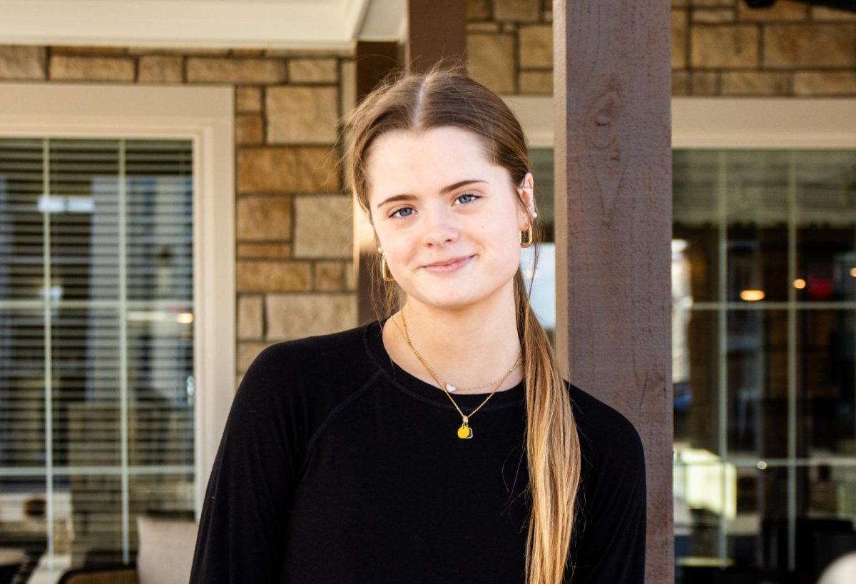 Senior Hazel Powers stands in the patio of the nursing home where she uses her nurse aide certification to assist residents with various daily tasks.